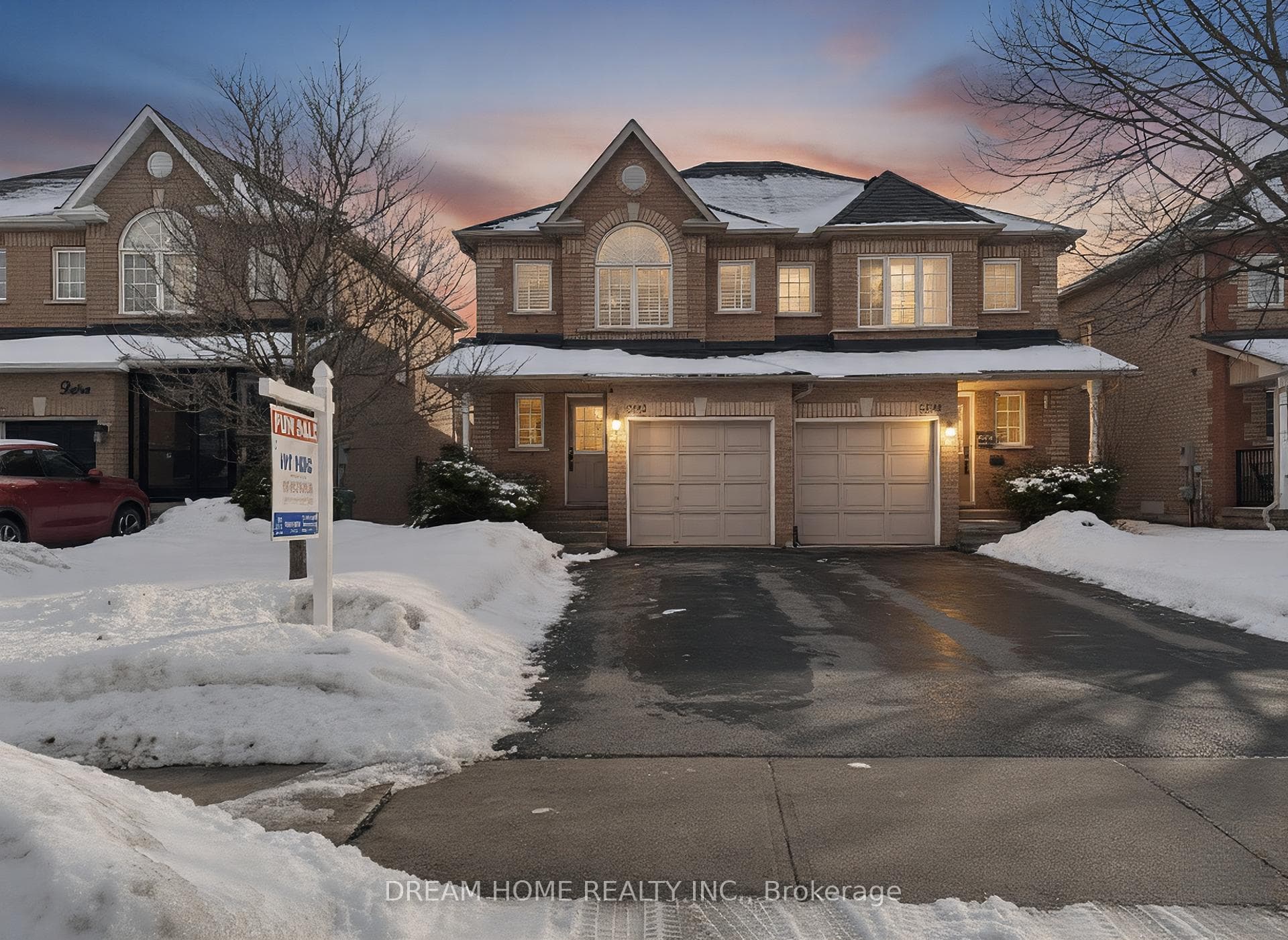 Stunning brick home at dusk with driveway
